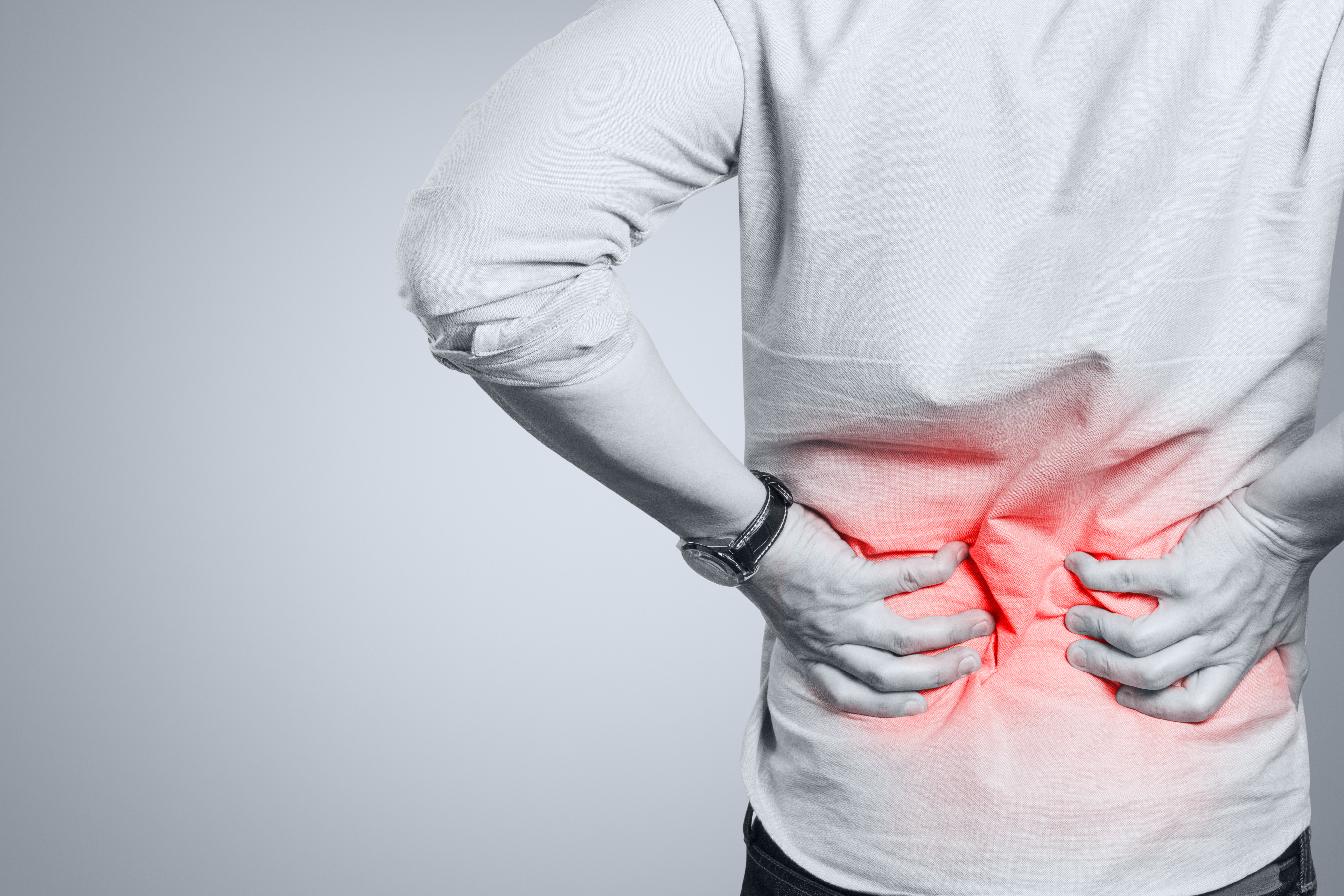 Person with back pain holding their back