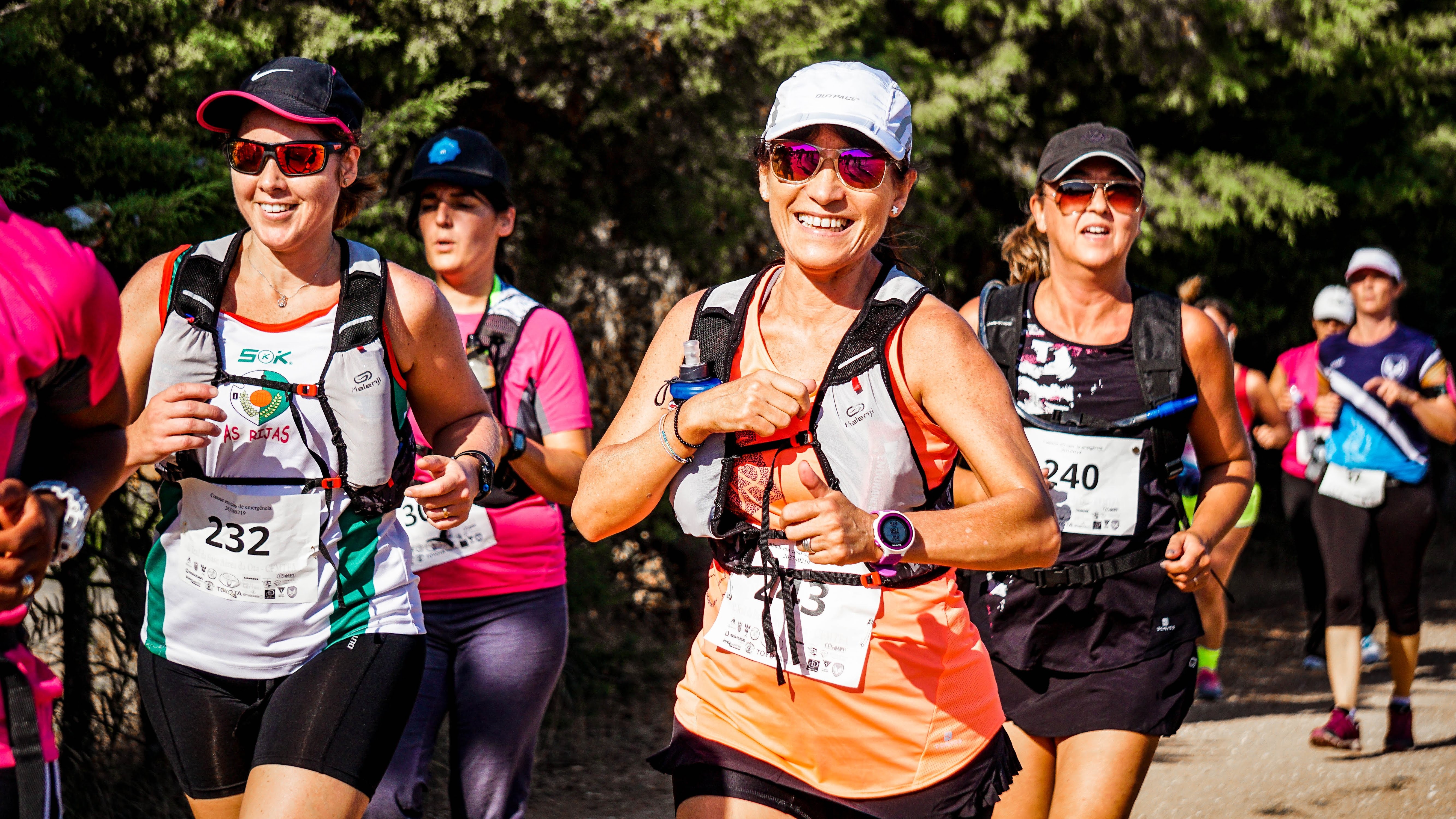 Women running in marathon towards a camera, while smiling